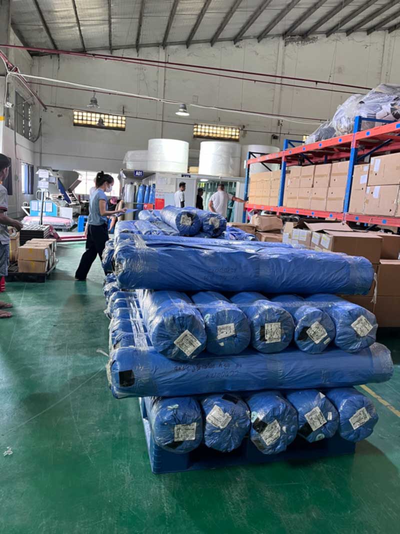 Labeled material rolls staged on pallets in the warehouse