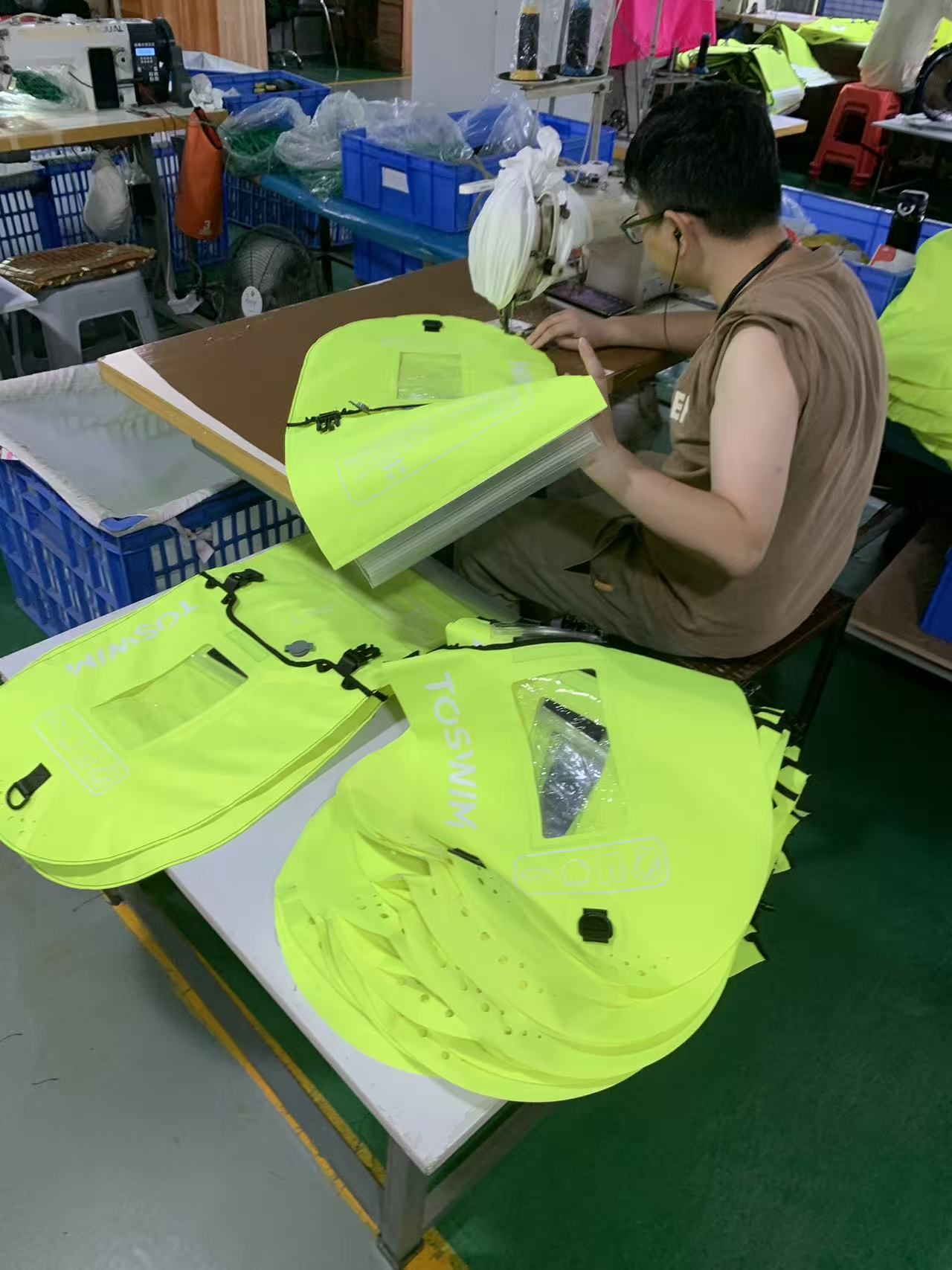 Operator sewing binding onto swim buoy panels